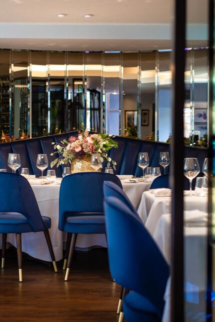 Elegant dining room with royal blue velvet chairs and mirrors at Chapter One Kent.