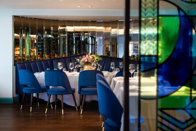 Elegant dining room with royal blue velvet chairs and mirrors at Chapter One Kent.