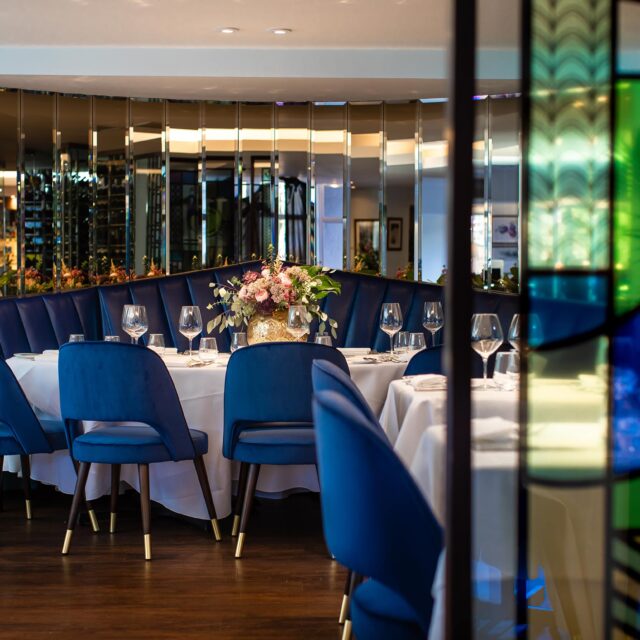 Elegant dining room with royal blue velvet chairs and mirrors at Chapter One Kent.