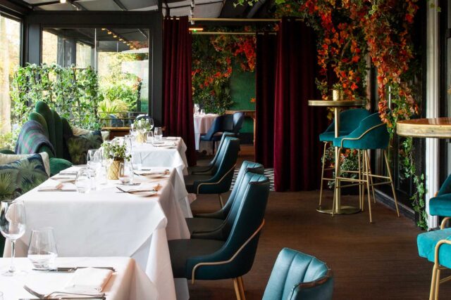 Luxury terrace dining setup with teal chairs and foliage at Chapter One Kent.